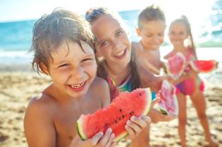 Kinder essen Wassermelone am Strand | HOFER REISEN